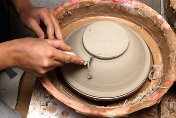 hands of a potter, creating an earthen jar on the circle
