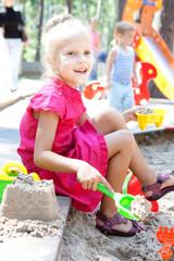 Little girl playing on a sandbox