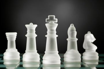 glass chess pieces in dark