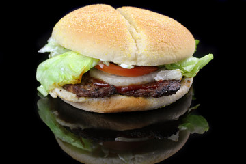 Hamburger with lettuce, tomato and onion isolated on black
