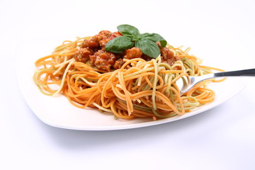 Spaghetti bolognese on a plate being eaten with a fork