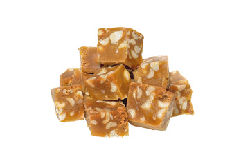 Heap of caramel fudge with nuts isolated on white