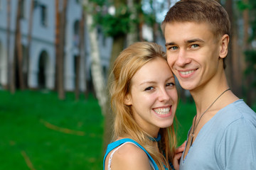 Smiling young couple with a building at the background