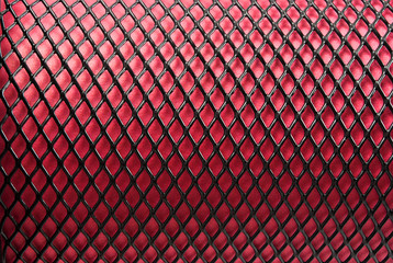 Metal grid on a red background.