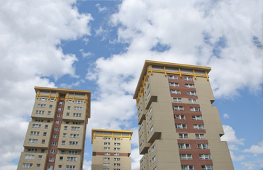 Three Yellow and Cream Apartments under a summer sky