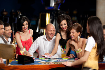 happy caucasian friends playing blackjack in casino