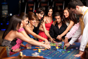 smiling people and dealer playing roulette