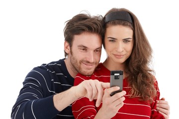 Happy couple using mobile phone smiling
