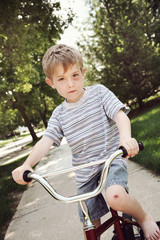 Obraz premium Young boy with injuries riding a bike