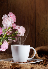 cup and coffee beans and flowers