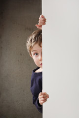 Boy peeking around a wall