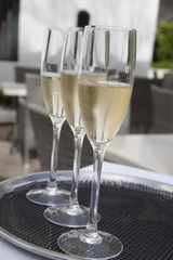 Three glasses of sparkling wine on a tray.