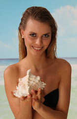 Frau mit Muschel am Strand