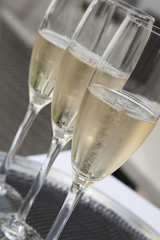 Three glasses of sparkling wine on a tray.