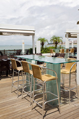 Beach cafe with  tables and chairs placed at the sea waterfront
