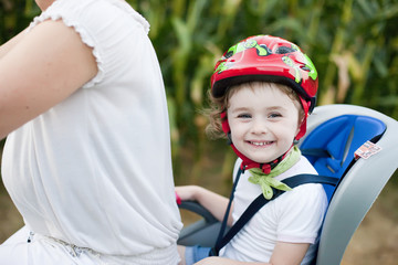 Bambina su bicicletta con casco