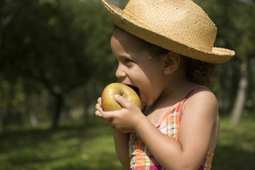 Portrait d'une jeune fille croquant dans une pomme