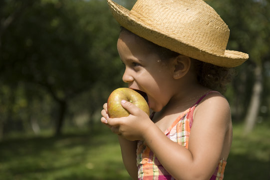 Portrait d'une jeune fille croquant dans une pomme