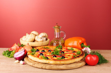 pizza and vegetables on red background