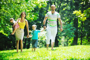 happy young couple with their children have fun at park