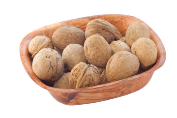 Whole walnuts in wooden plate. isolated on white.