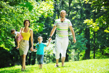 Fototapeta premium happy young couple with their children have fun at park