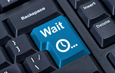 Button wait computer keyboard with clock icon.