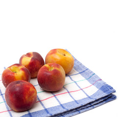 juicy peaches lying on kitchen towel and empty space