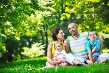 Fototapeta premium happy young couple with their children have fun at park