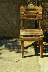Single old wooden chair on sidewalk in Rethymno