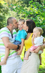Fototapeta premium happy young couple with their children have fun at park