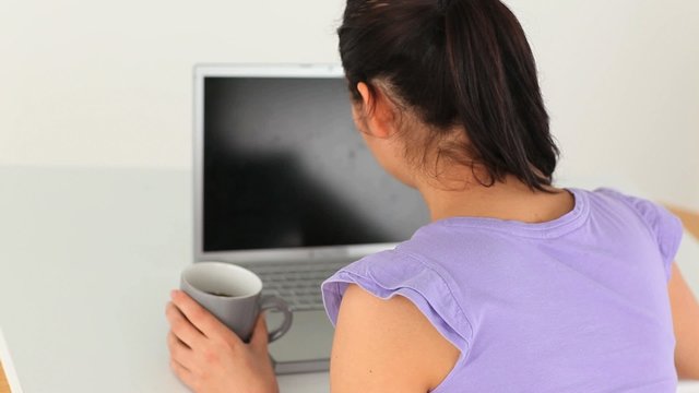 Young woman with a laptop and a cup
