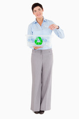 Woman putting a plastic bottle in a recycling box