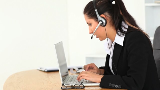 Businesswoman with a headset and a laptop