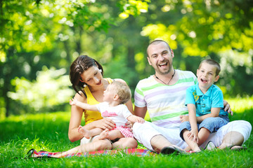 happy young couple with their children have fun at park