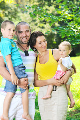 happy young couple with their children have fun at park