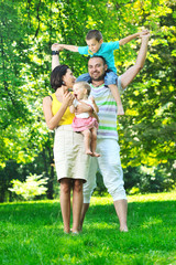 Fototapeta premium happy young couple with their children have fun at park