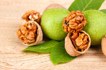 walnuts and leaves on wooden background
