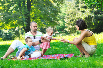 happy young couple with their children have fun at park