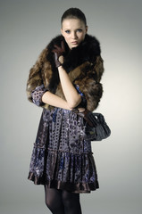 High fashion model in autumn/winter clothes with handbag posing