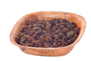 raisins in wooden plate. isolated on white.