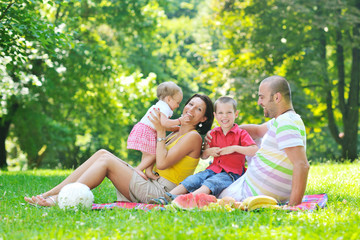 Fototapeta premium happy young couple with their children have fun at park