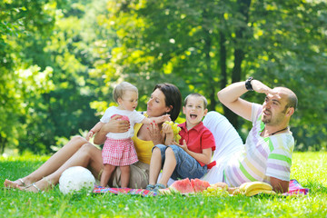 Fototapeta premium happy young couple with their children have fun at park