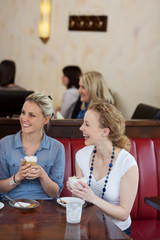 freundinnen lachen im café