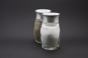 Condiments. Salt and Pepper on a black background