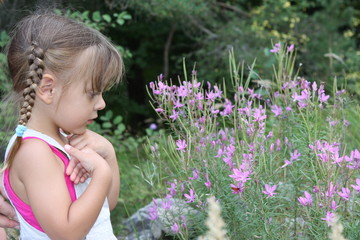 petite fille contemplant des fleurs