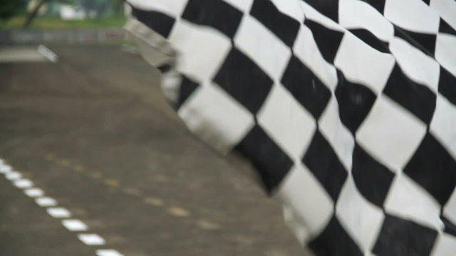 Racing checkered flag waving at race track