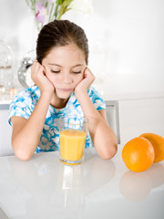 bored little girl with orange juice
