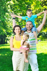 Fototapeta premium happy young couple with their children have fun at park