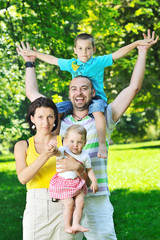 happy young couple with their children have fun at park